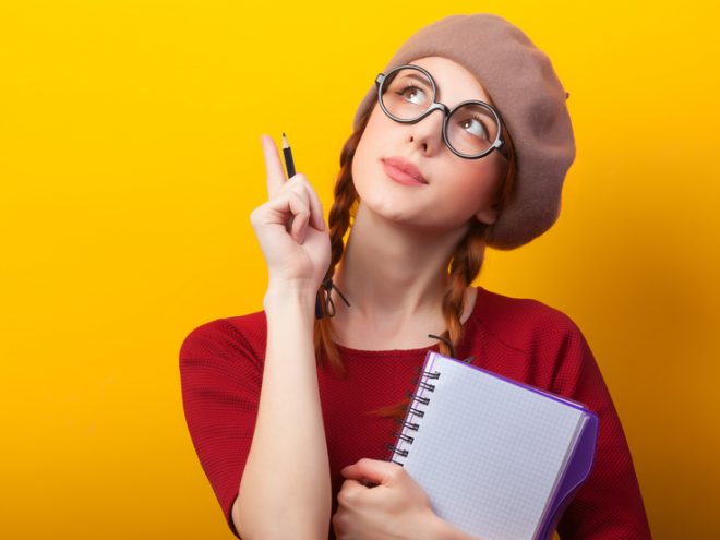 Why Thinking Strategically is Critical to Your Success. 4 Swing Thoughts to Get You There. Redhead girl with notebook and pencil on yellow background.