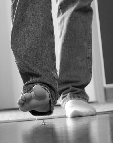 Man stepping on thumbtack